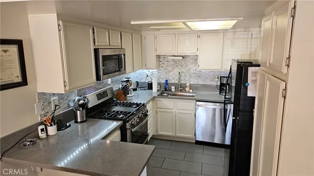 a kitchen with stainless steel appliances a sink stove and refrigerator