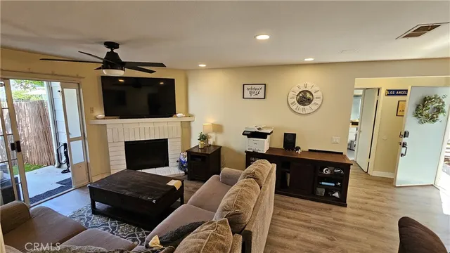 a living room with furniture a flat screen tv and a fireplace