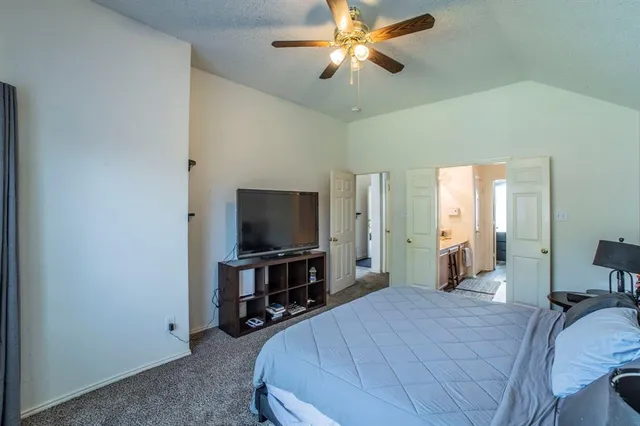 a bedroom with a bed and a flat tv screen on the dresser