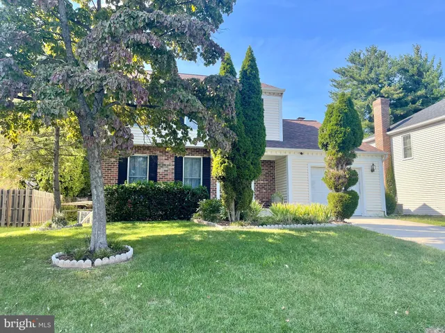 a front view of a house with a yard and tree