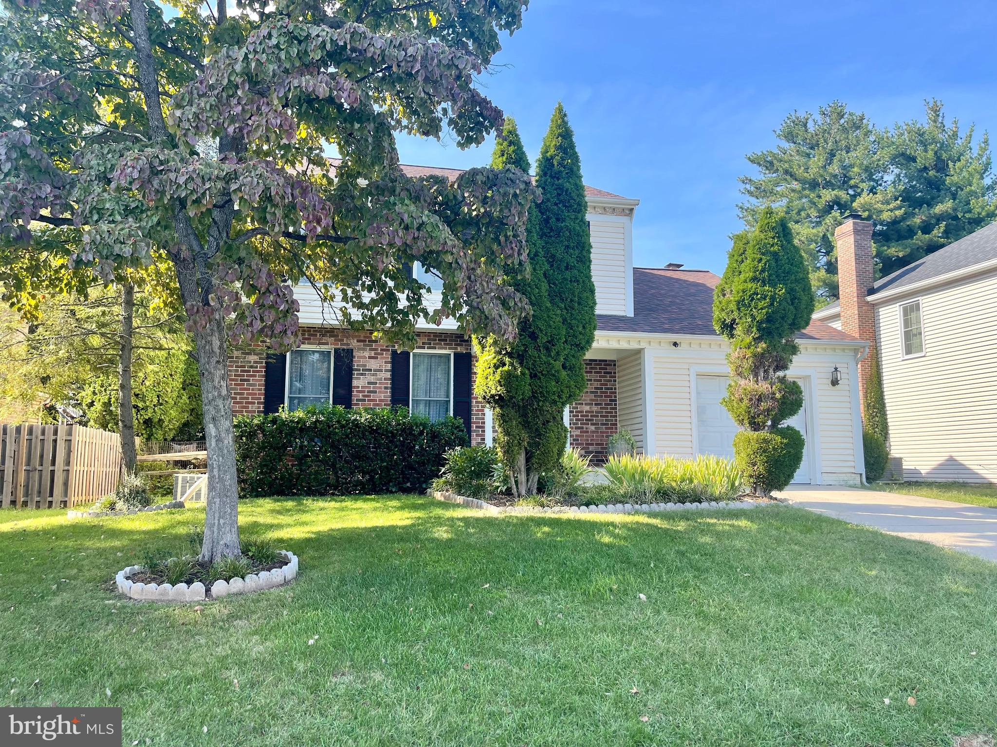 a front view of a house with a yard and tree