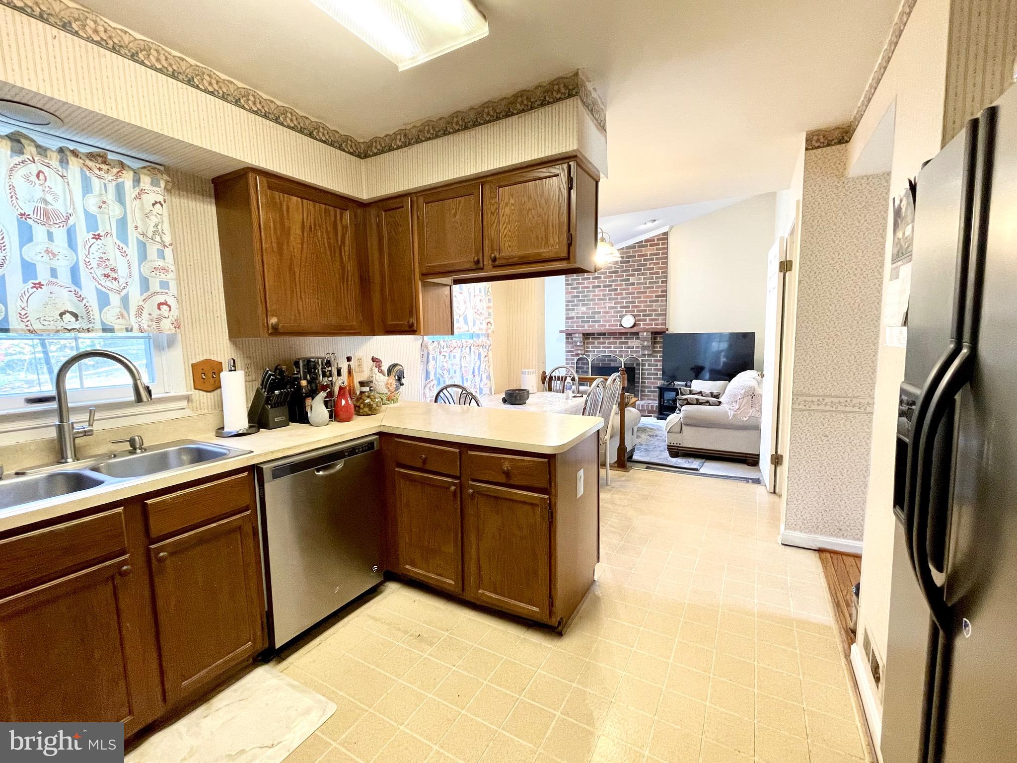 12125 Stoney Bottom Road Germantown, MD 20874 - Photo 7 of 23 a kitchen with stainless steel appliances granite countertop a sink dishwasher stove and refrigerator with wooden floor