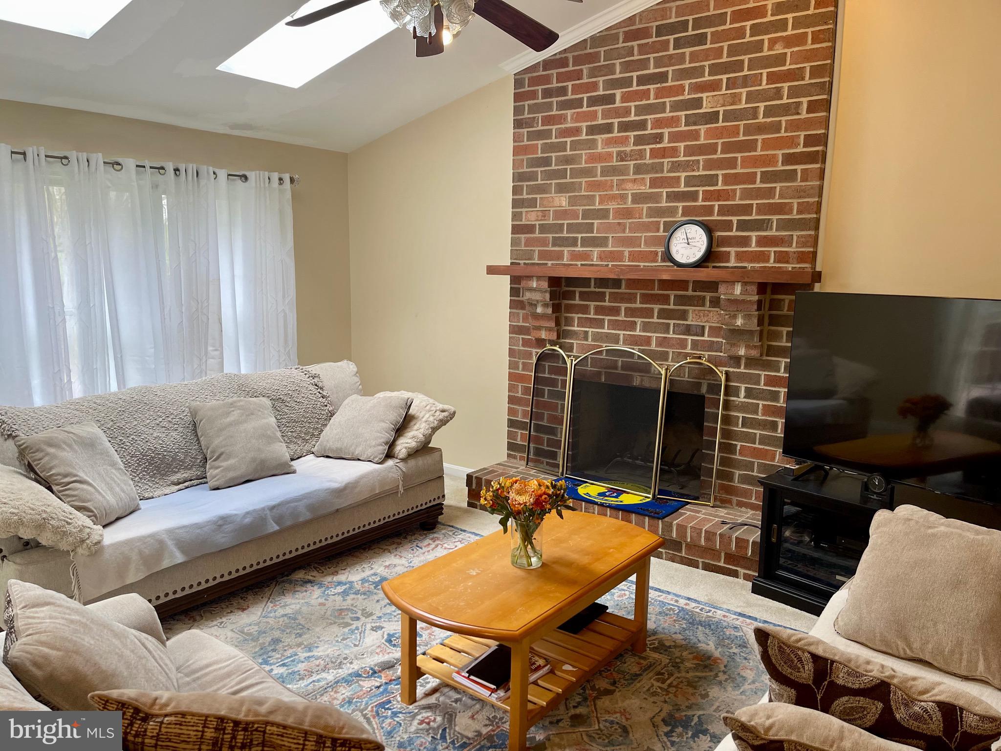 12125 Stoney Bottom Road Germantown, MD 20874 - Photo 10 of 23 a living room with furniture a fireplace and a flat screen tv