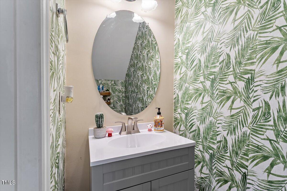 5730 Clearbay Lane Raleigh, NC 27612 - Photo 15 of 32 a bathroom with a sink and mirror with painted walls
