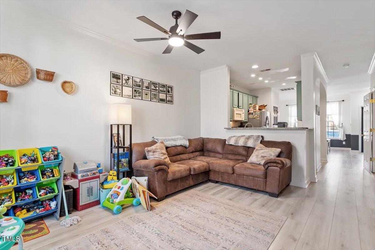 5730 Clearbay Lane Raleigh, NC 27612 - Photo 20 of 32 a living room with furniture and a wooden floor