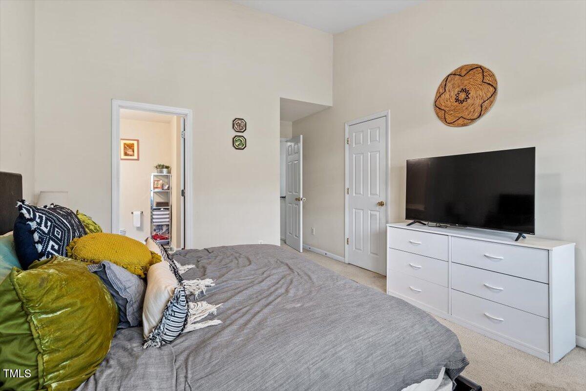 5730 Clearbay Lane Raleigh, NC 27612 - Photo 23 of 32 a bedroom with a bed and a flat screen tv