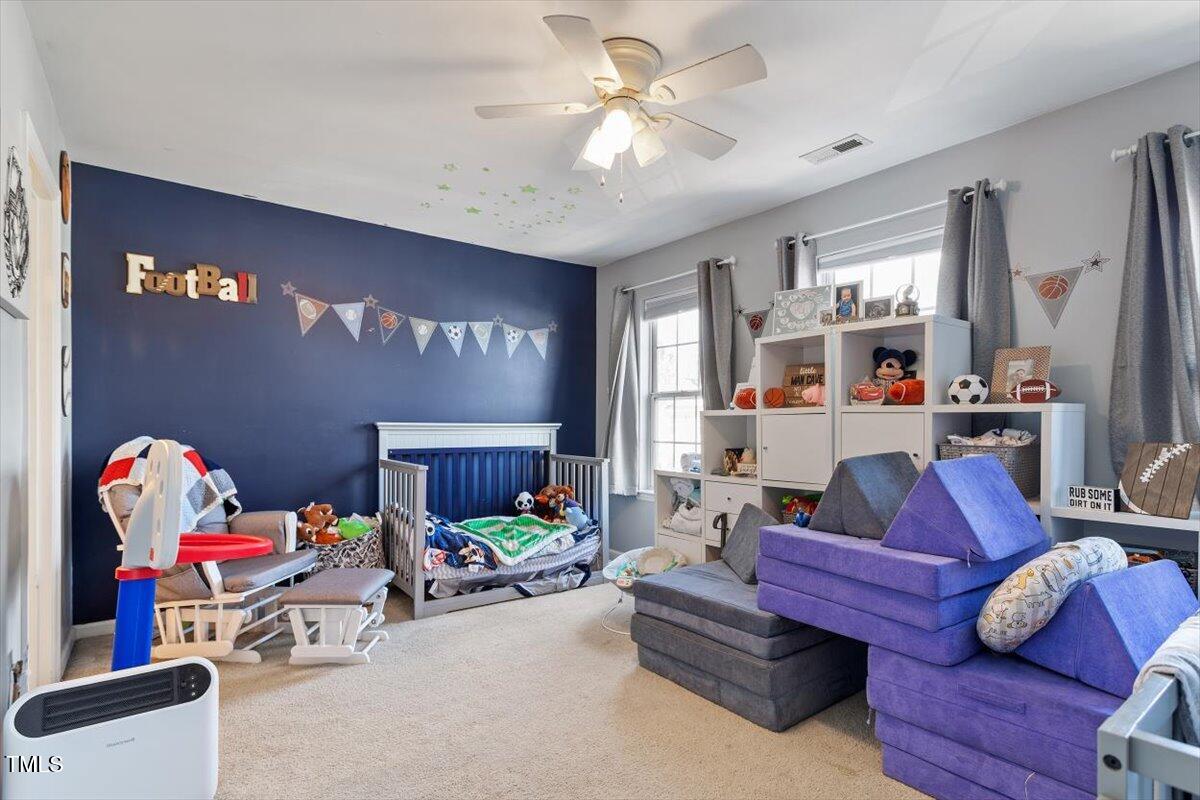 5730 Clearbay Lane Raleigh, NC 27612 - Photo 27 of 32 a living room with furniture fireplace and a chandelier