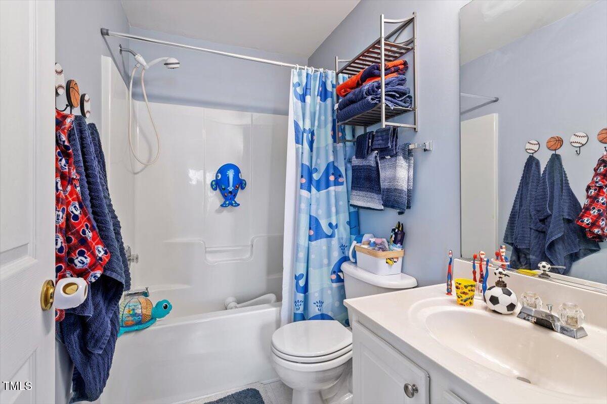 5730 Clearbay Lane Raleigh, NC 27612 - Photo 29 of 32 a bathroom with a sink toilet and shower curtain