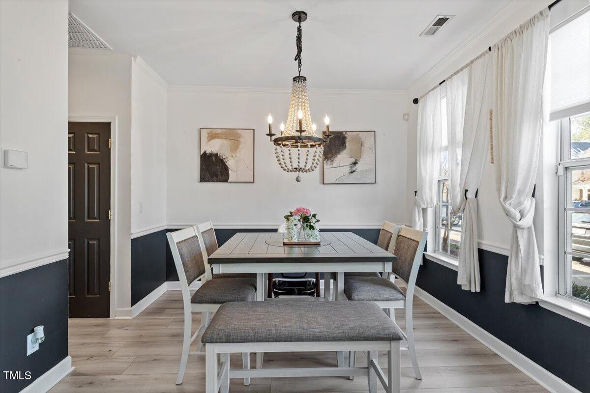 5730 Clearbay Lane Raleigh, NC 27612 - Photo 7 of 32 a view of a dining room with furniture wooden floor and a chandelier