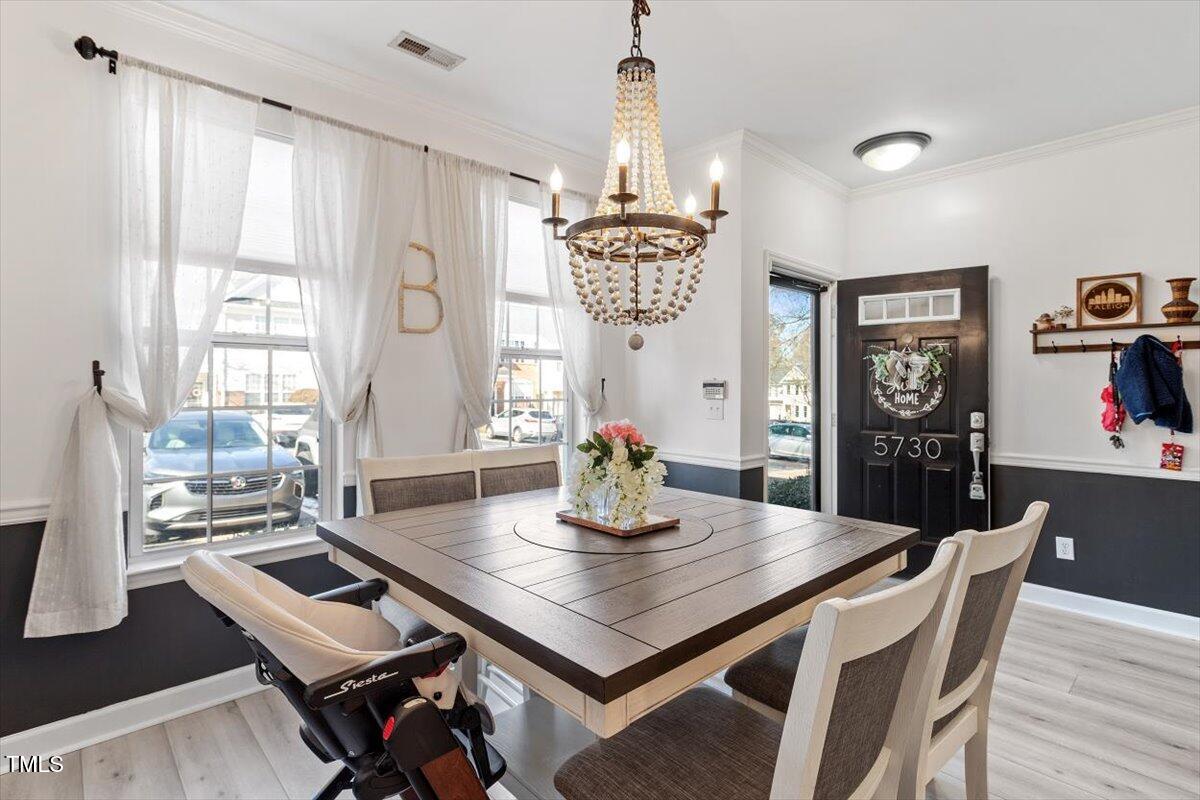 5730 Clearbay Lane Raleigh, NC 27612 - Photo 8 of 32 a view of a dining room with furniture window and wooden floor