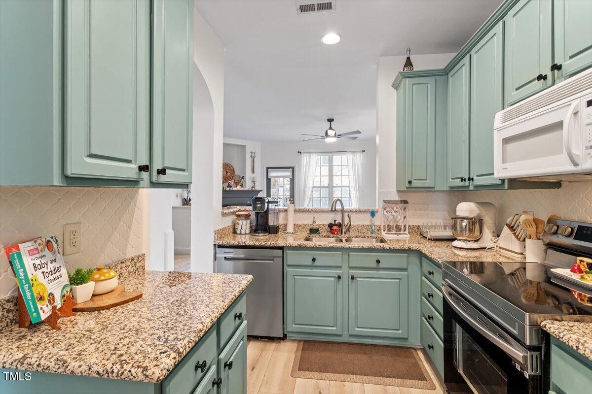 5730 Clearbay Lane Raleigh, NC 27612 - Photo 9 of 32 a kitchen with a sink a stove and cabinets