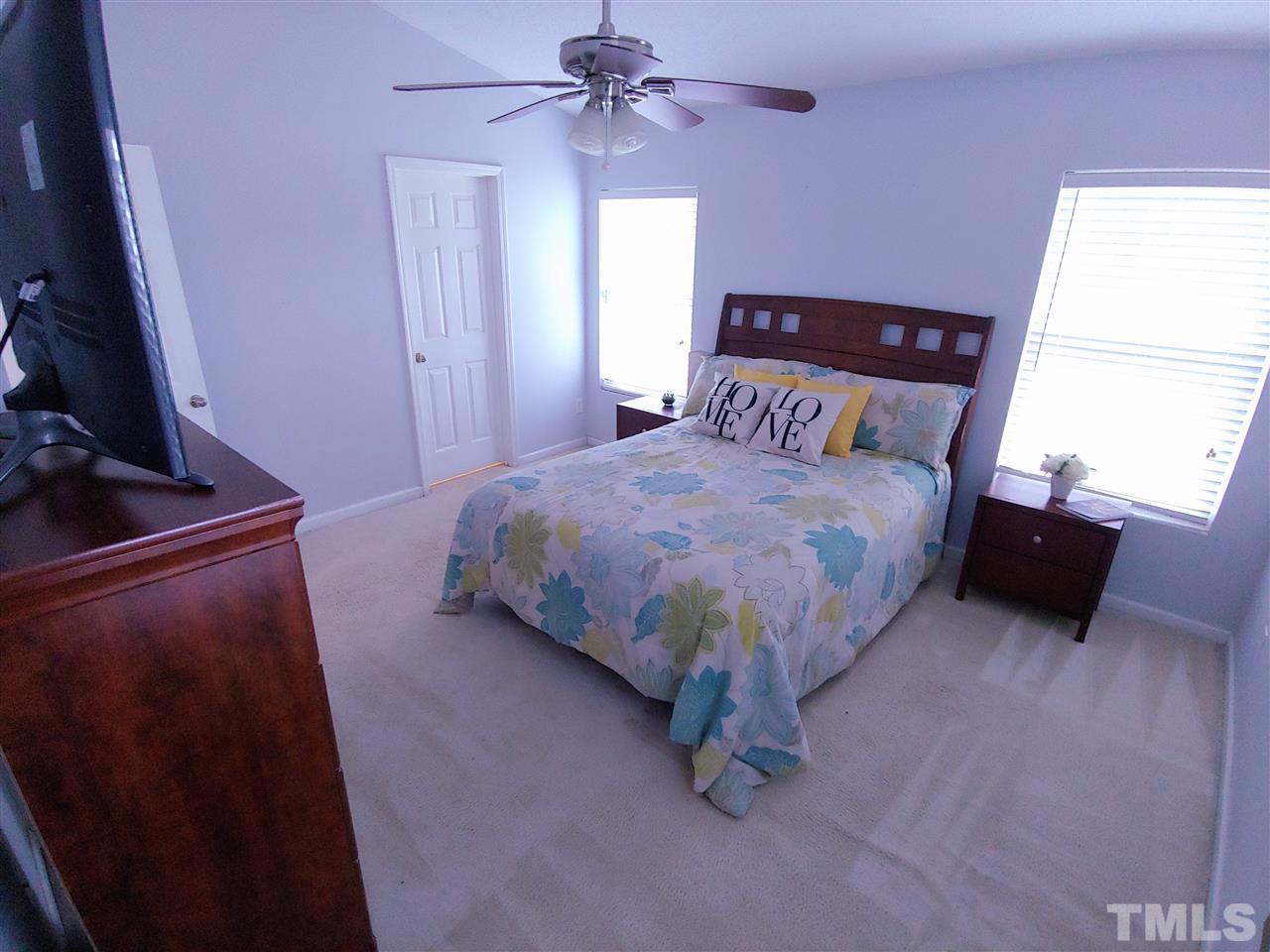 3101 Marcony Way Raleigh, NC 27610 - Photo 12 of 16 a bedroom with a bed and a flat tv screen on dresser