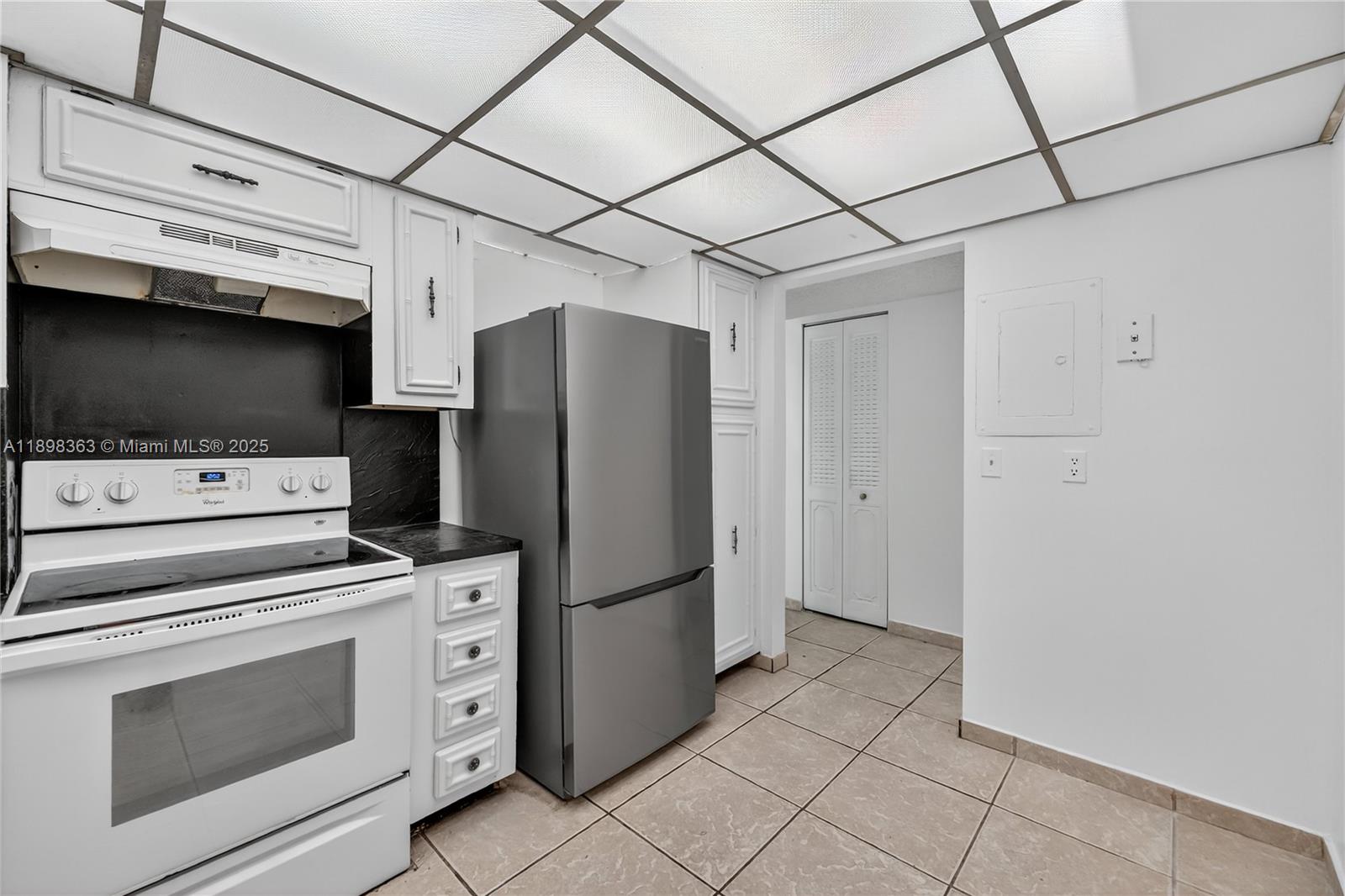 2655 Collins Avenue, Unit 1502 Miami Beach, FL 33140 - Photo 7 of 11 a kitchen with stainless steel appliances a refrigerator and a stove top oven