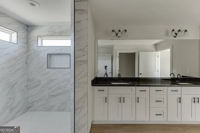 a bathroom with a granite countertop sink and a mirror