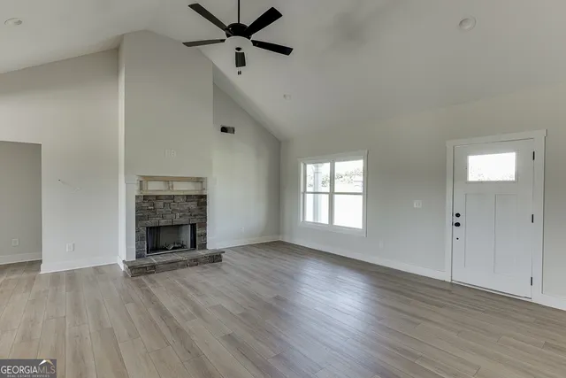 wooden floor fireplace and windows in an empty room