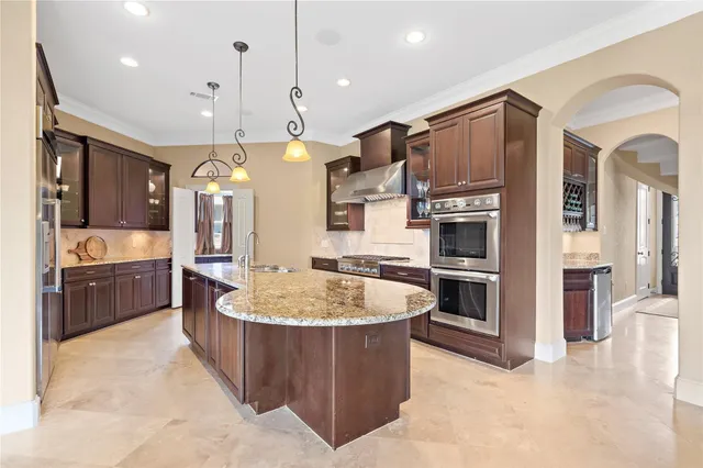 a kitchen with granite countertop a sink and refrigerator