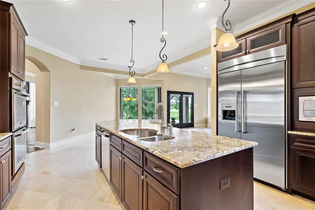 a large kitchen with stainless steel appliances granite countertop a stove and a view of living room