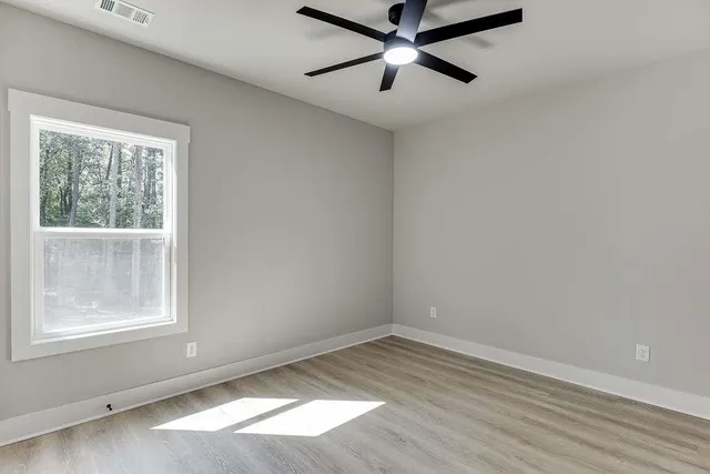 an empty room with a window and a fan