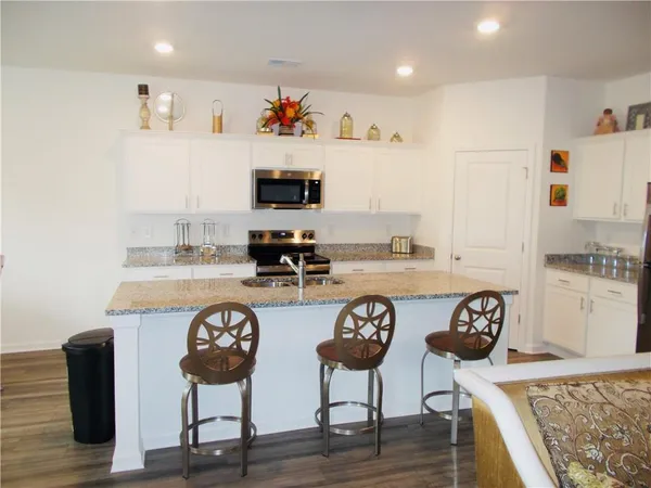 a kitchen with cabinets and chairs