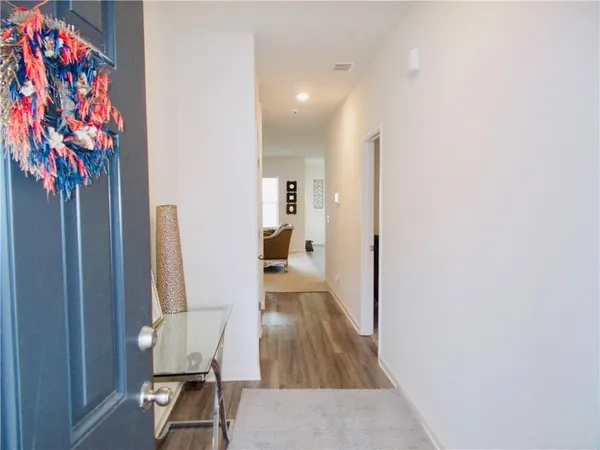 a view of a hallway with wooden floor and a potted plant