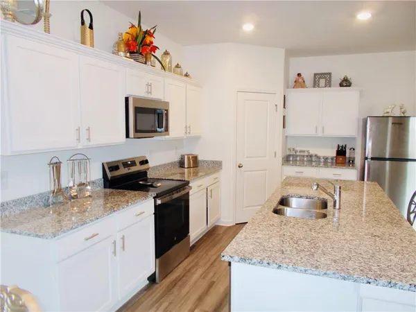 a kitchen with stainless steel appliances granite countertop a sink stove and refrigerator