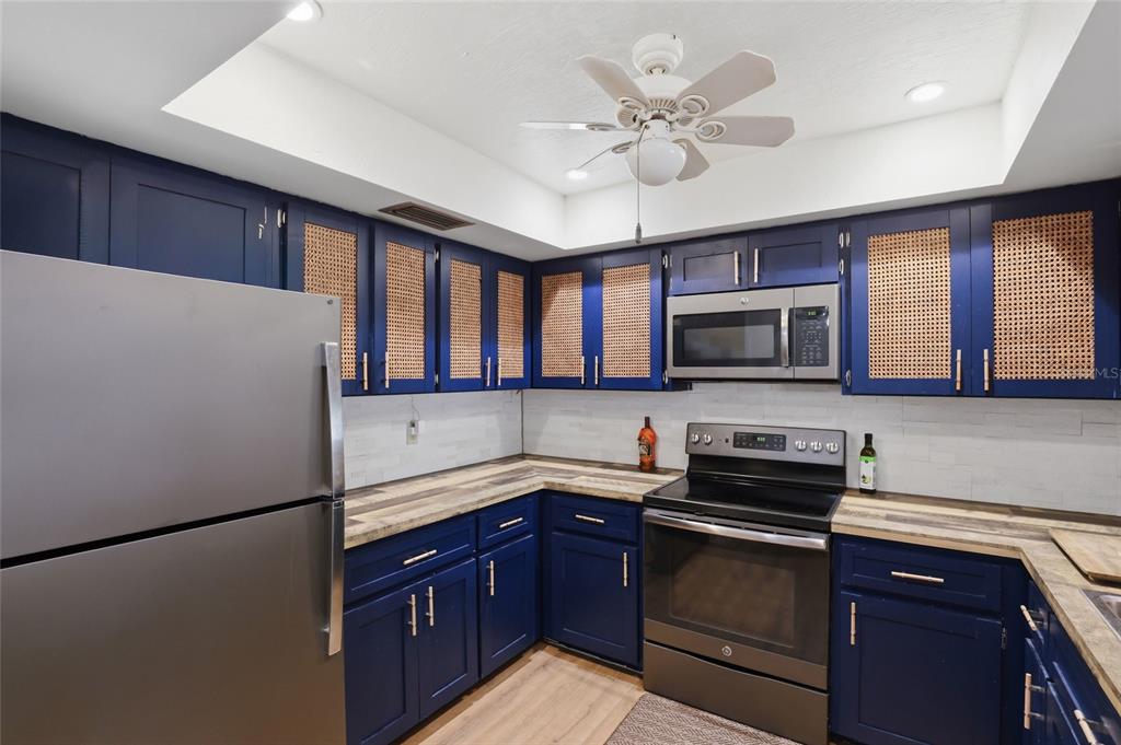 4576 Bliss Road Sarasota, FL 34233 - Photo 13 of 40 a kitchen with stainless steel appliances granite countertop a refrigerator a stove a sink dishwasher and a microwave oven with cabinets