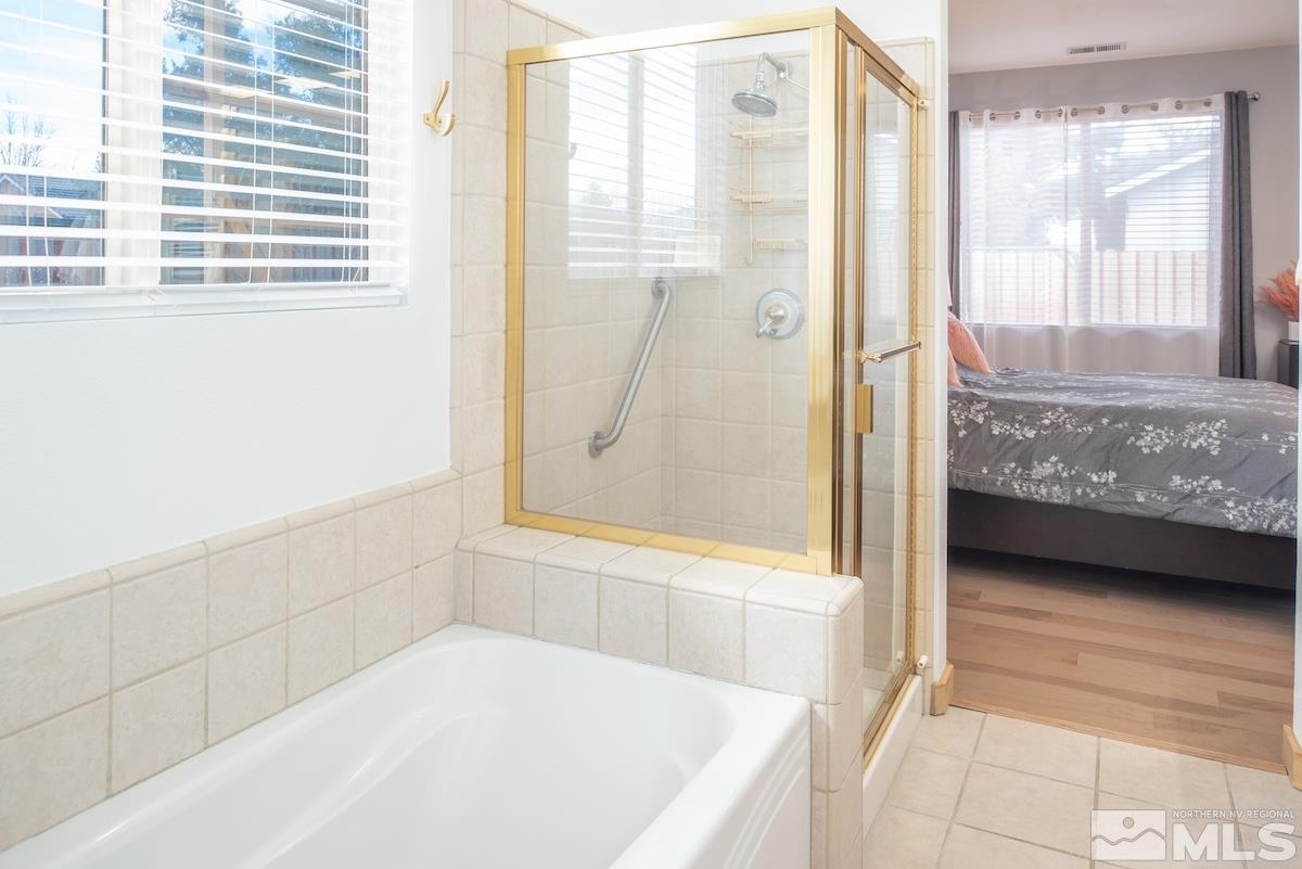 10417 Chadwell Drive Reno, NV 89521 - Photo 16 of 40 a bathroom with a tub and a shower