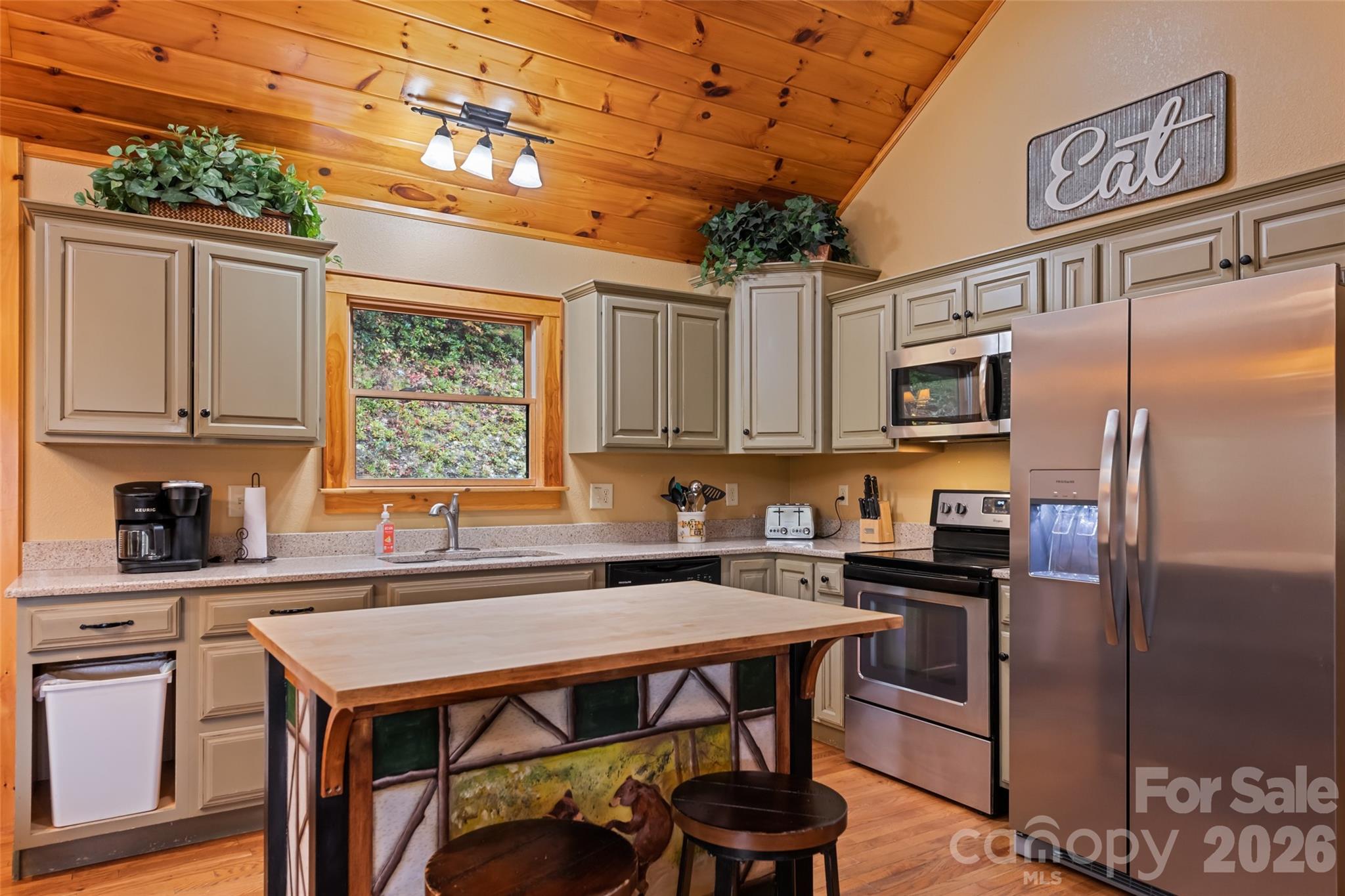 235 Soaring Eagle Road Bryson City, NC 28713 - Photo 14 of 42 a kitchen with stainless steel appliances granite countertop a stove a refrigerator a sink a dining table and chairs with wooden floor