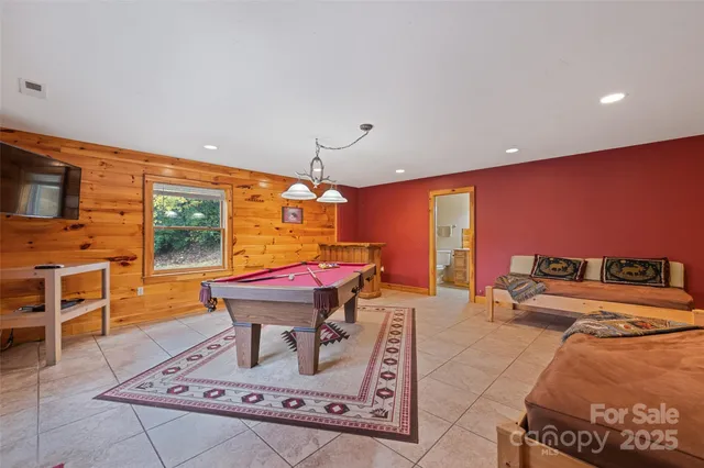 a living room with furniture a flat screen tv and a pool table