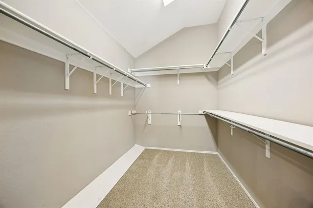 a view of a kitchen with a sink and dishwasher with white cabinets