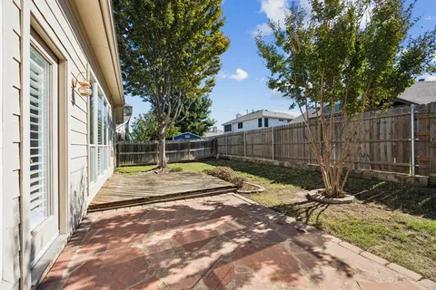 a view of backyard with wooden fence and trees