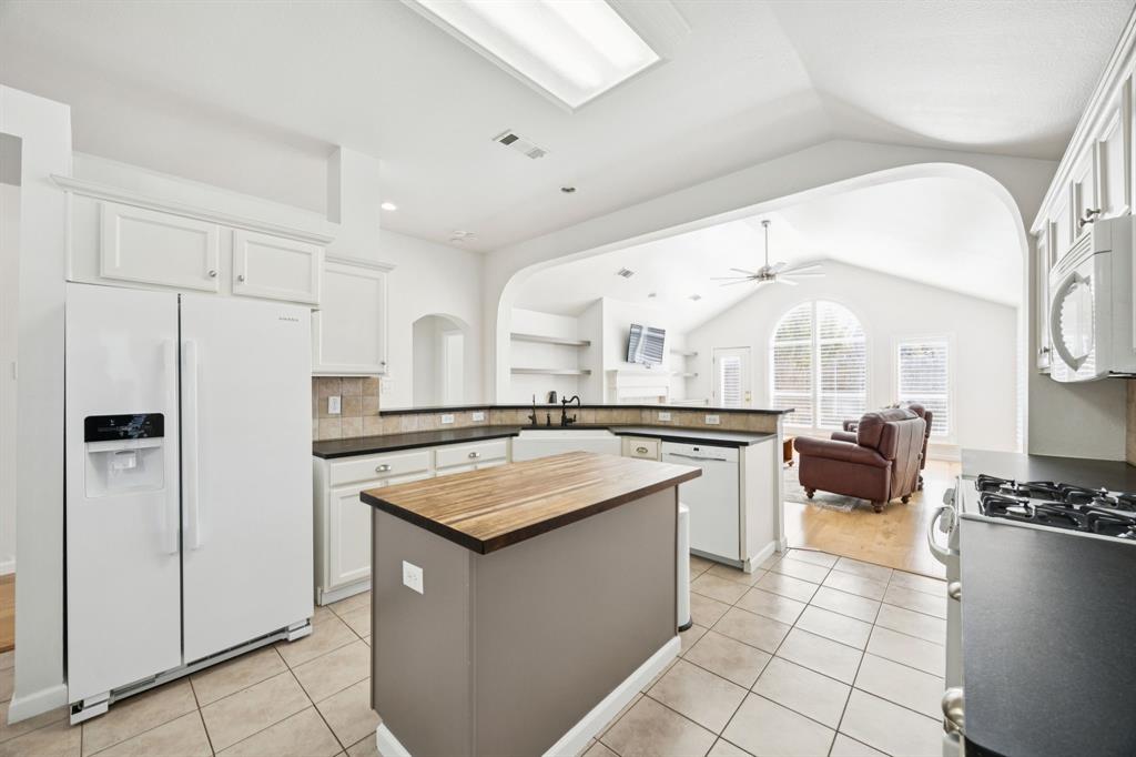3012 Mason Avenue Corinth, TX 76210 - Photo 28 of 28 a kitchen with a sink a stove a refrigerator and white cabinets