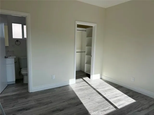 an empty room with wooden floor and closet