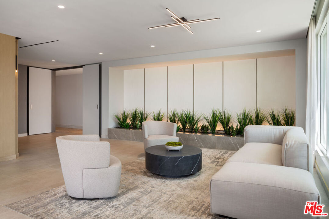 12431 Rochester Avenue, Unit 102 Los Angeles, CA 90025 - Photo 26 of 28 a living room with furniture and a potted plant