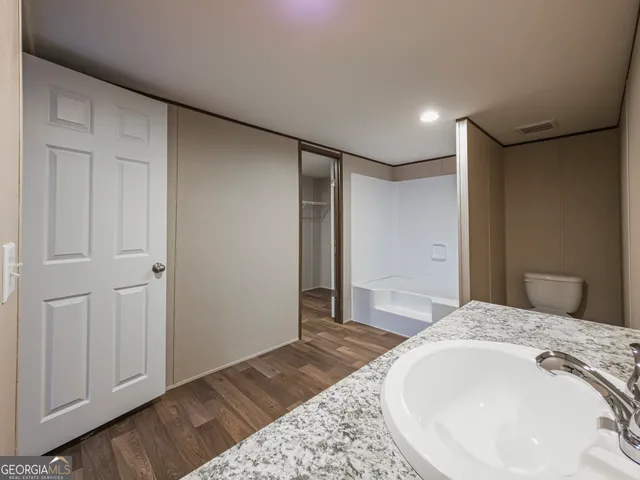 a spacious bedroom with a bed and a dresser