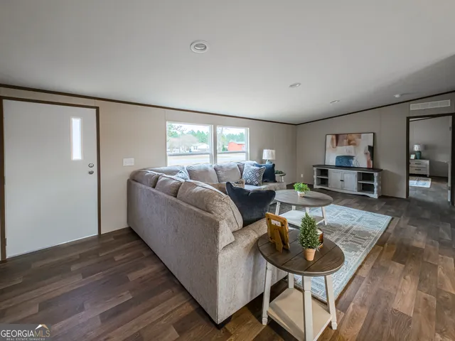 a living room with furniture and a wooden floor
