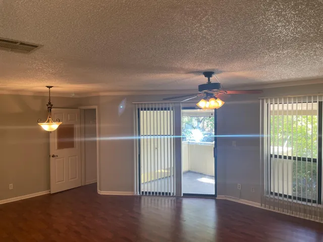 a view of a hallway with wooden floor and windows