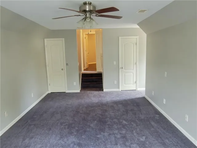 a view of a room with a ceiling fan and a window