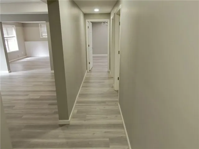 a view of a hallway with wooden floor and entryway