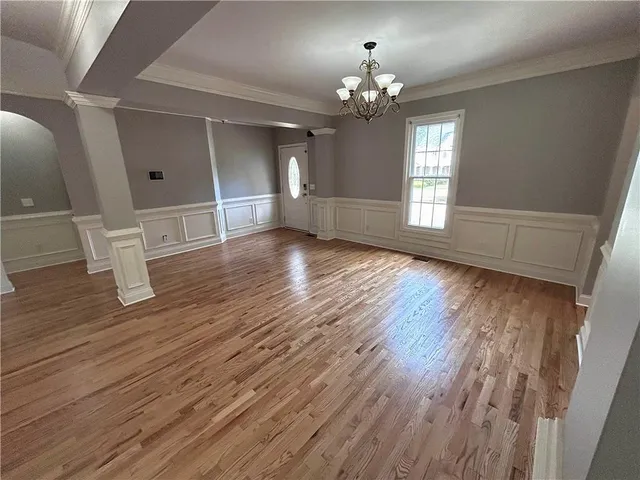 a view of empty room with wooden floor and window