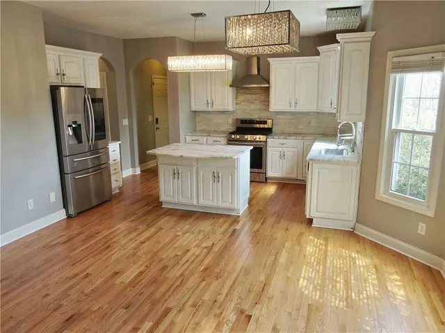 a kitchen with stainless steel appliances a stove refrigerator and cabinets