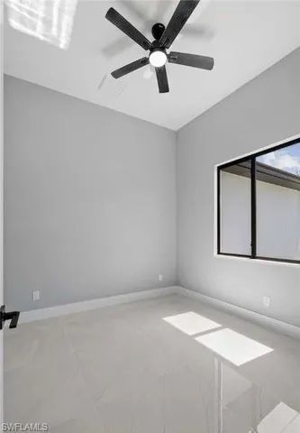 an empty room with a window and a fan