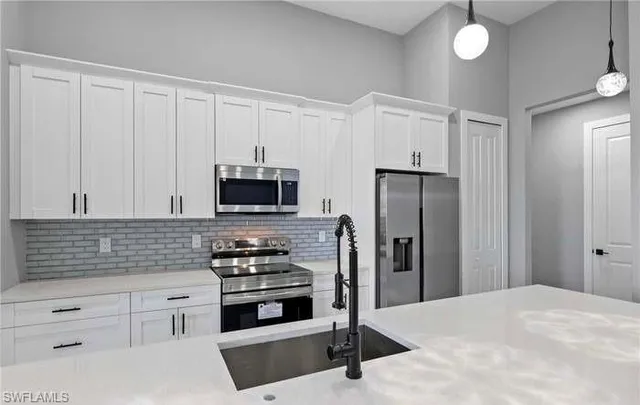 a kitchen with stainless steel appliances white cabinets and a refrigerator