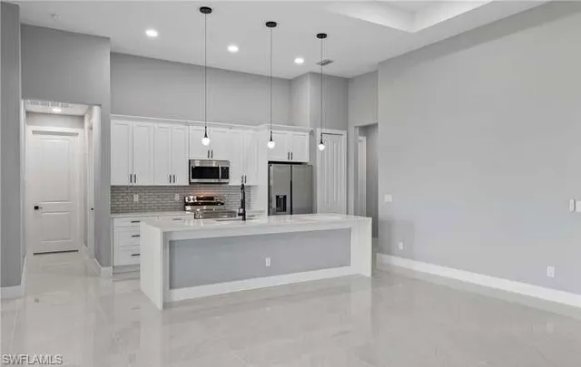 a large kitchen with kitchen island a sink stainless steel appliances and cabinets