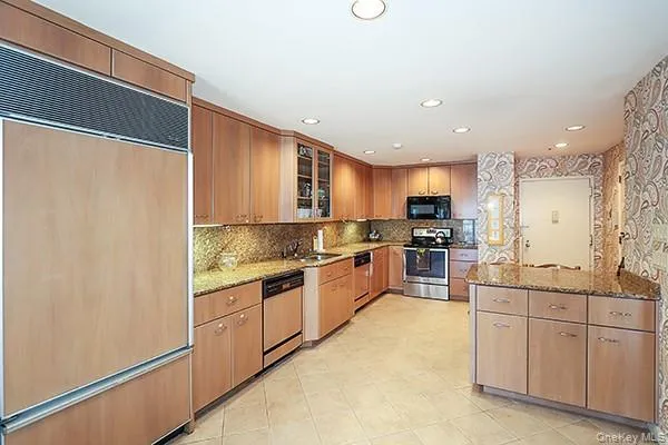 a large kitchen with granite countertop a sink and cabinets
