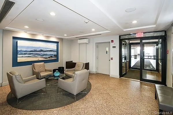 a view of a hallway with wooden floor and a bathroom