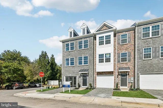 a view of a white building among the street and trees