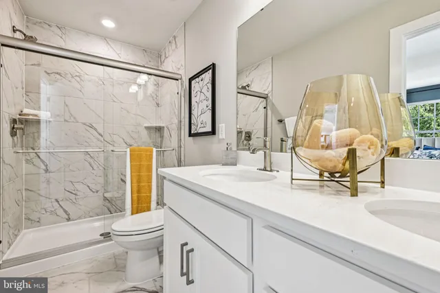 a bathroom with a sink mirror vanity and toilet
