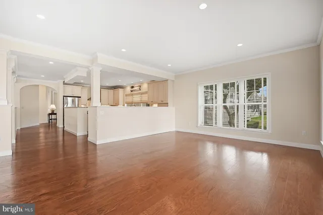 a view of an empty room with window and wooden floor