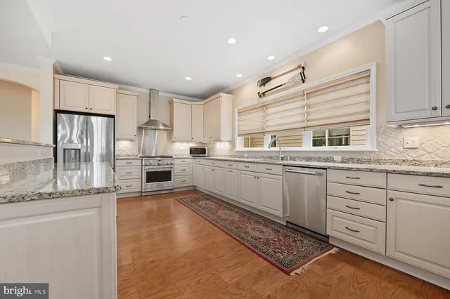 a kitchen with white cabinets and stainless steel appliances